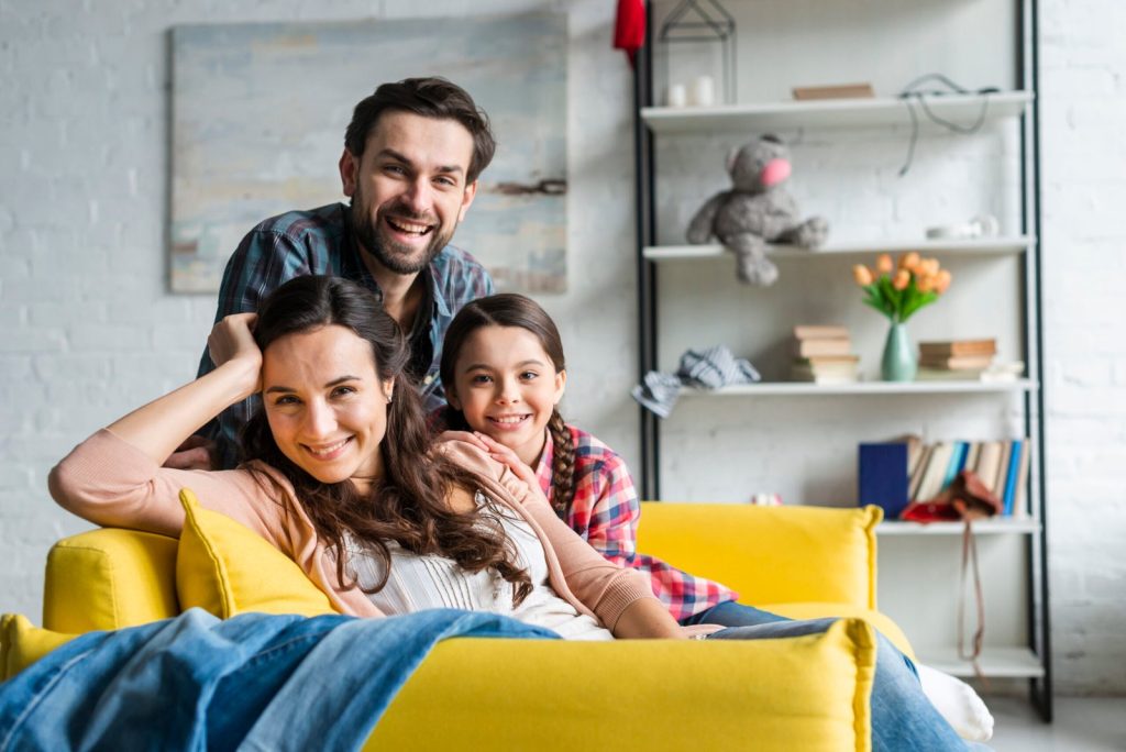 happy-family-sitting-couch-living-room-scaled
